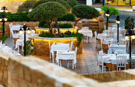 Exterior of a restaurant with tables and chairs on the street.の写真素材