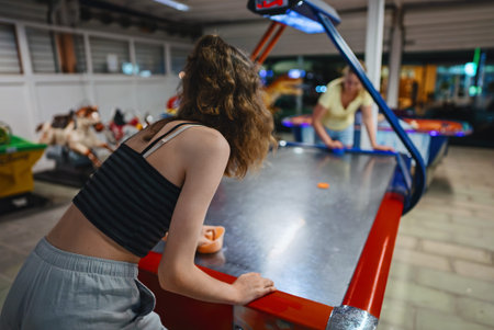 Family plays air hockey in the entertainment center.