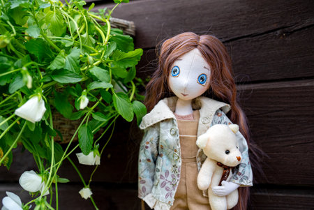 Handmade doll of a girl with a bear. Children's toy.の写真素材