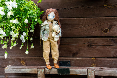 Handmade doll of a girl with a bear. Children's toy.