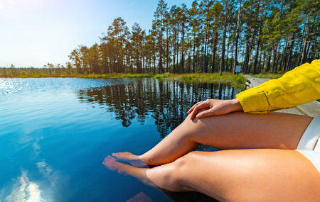 Woman relaxing by a Bog Lake. New travel trend.の写真素材