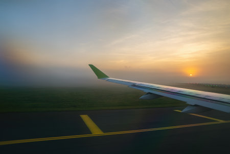 The plane takes off in the fog at dawn.の写真素材