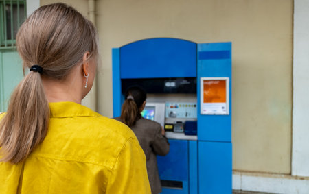 A woman buys a train ticket at a ticket machine.の写真素材