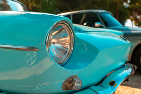 Classic turquoise car with shiny headlight and chrome details.の写真素材
