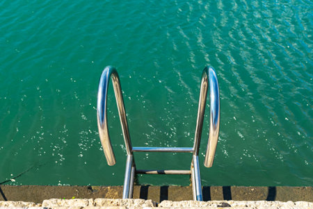 Metal ladder leading into the water.の写真素材