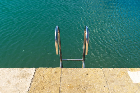 Metal ladder leading into the water.の写真素材