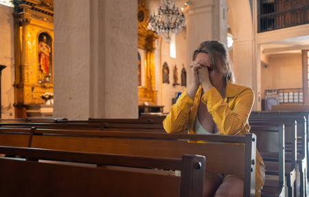 Woman is sitting in a church and praying.の写真素材