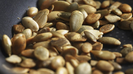 Pumpkin seeds are fried in a frying pan.の写真素材