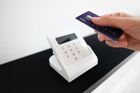 Woman's hand making a contactless payment with a card on a wireless terminal.