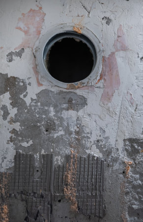 An old concrete wall during renovation with a ventilation opening.の写真素材