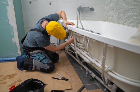 Man servicing the pipe system of a bathtub with hydromassage.の写真素材