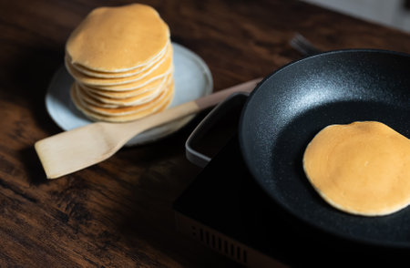 Cooking pancakes in pan on stove. Homemade breakfast.の写真素材