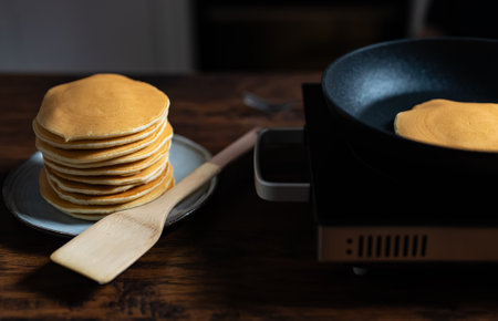 Cooking pancakes in pan on stove. Homemade breakfast.の写真素材