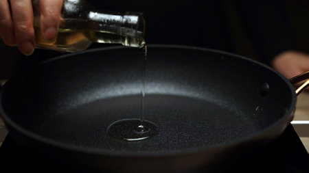 Chef Adding Oil to Preheated Frying Pan.の写真素材
