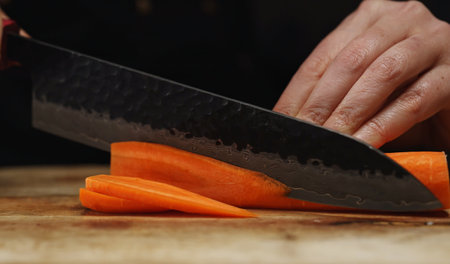 Female Chef Slicing Carrots into Julienne Strips.の写真素材