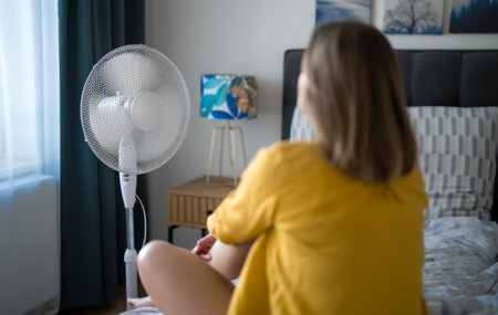 Woman suffering from extreme summer heat indoors.の写真素材
