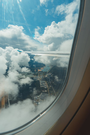 Scenic aerial view of houses, lakes, and clouds below.の写真素材