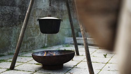 Medieval pot hanging over fire with cooking food.の写真素材