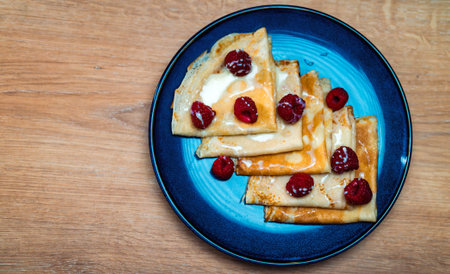 Pancakes with raspberries and condensed milk.の写真素材