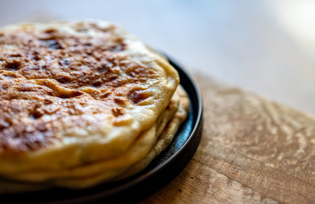Freshly baked flatbreads served on wooden board.