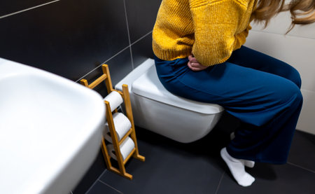 Unrecognizable woman on the toilet with stomach pain.の写真素材