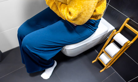 Unrecognizable woman on the toilet with stomach pain.の写真素材