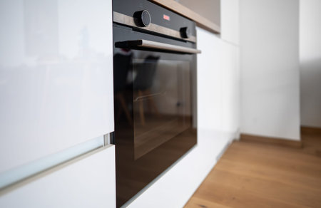 Black modern oven in a built-in kitchen.