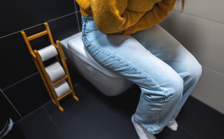 Unrecognizable woman on the toilet with stomach pain.の写真素材