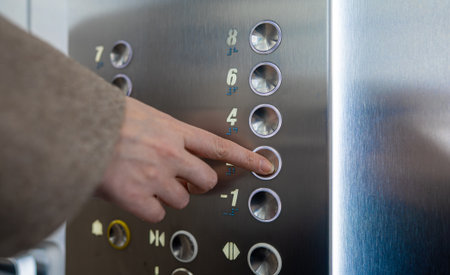 Woman pressing button inside elevator.の写真素材