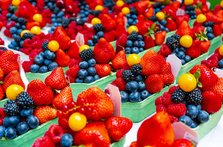 Fresh summer berries displayed in small market baskets.の写真素材
