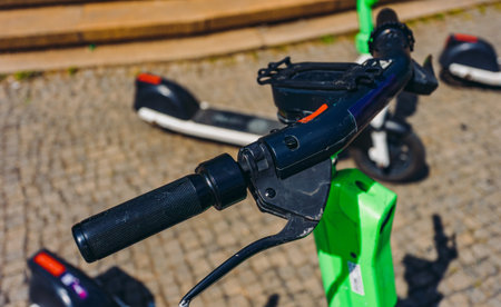 Green electric scooters parked on city street.の写真素材