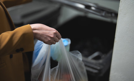 Woman throwing away garbage into trash bin.の写真素材