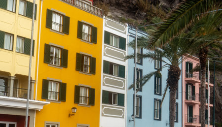 Colorful apartment buildings with balconies and palm trees in a city.の写真素材