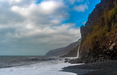 Coastal mountain landscape with volcanic pebble beach.の写真素材