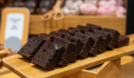 Sliced dark chocolate sponge cake on board.の写真素材