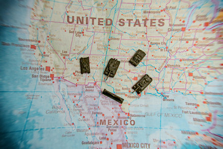 Military tanks and wall on USA Mexico border map.の写真素材