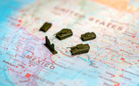 Military tanks and wall on USA Mexico border map.の写真素材