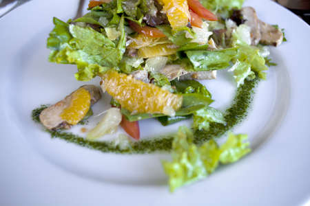 Salad with meat and herbs on a white plateの写真素材