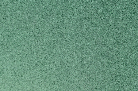 Green rubber covering for sports and playgrounds.