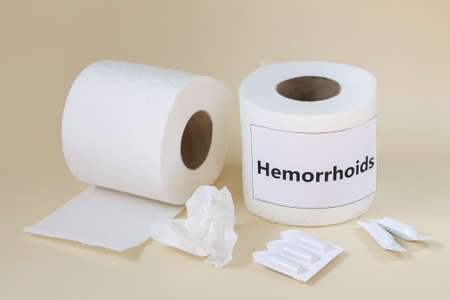 Hemorrhoids and constipation treatment concept. Toilet paper rolls and medical suppositoriesの写真素材