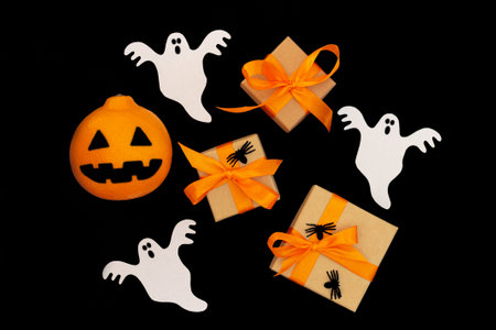 Halloween background top view. Present boxes, spiders, paper ghosts and orange jack headの写真素材