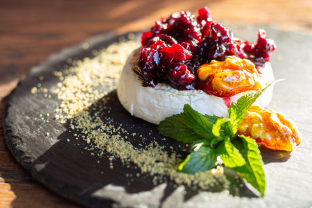 Camembert cheese baked with berry sauce, nuts, mint and honey close-upの写真素材