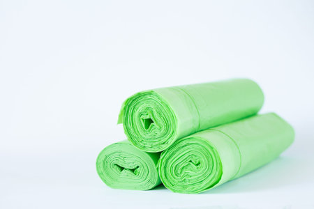Three rolls of biodegradable eco plastic green bags isolated on white background. Zero waste...