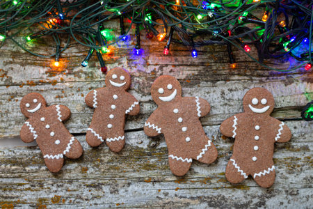 Christmas bakery and gingerbreads cookies with colorful lights top view on wooden table