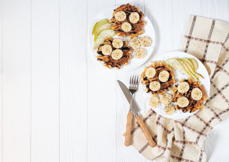 Belgium waffles with chocolate, banana, pear and chia seeds for breakfast top viewの写真素材