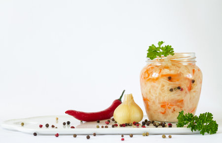 Sauerkraut or fermented white cabbage, carrot with spices and herbs. Open glass jar of merinated vegetablesの写真素材