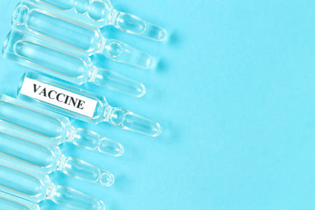 Glass medical vials with liquid on blueの写真素材