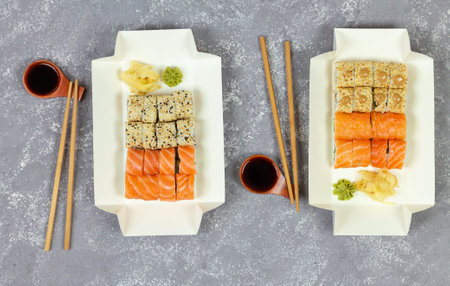 Various sushi selection in white eco paper packaging tray on gray stone background overhead viewの写真素材