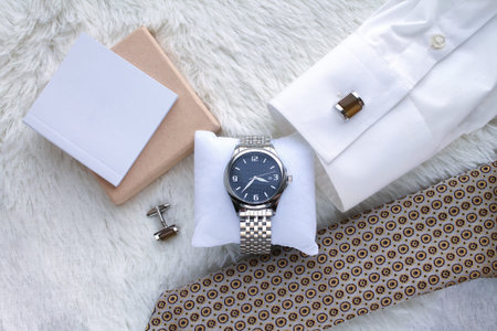Flat lay composition with men's luxury wrist watch, tie, shirt and cufflinks top view