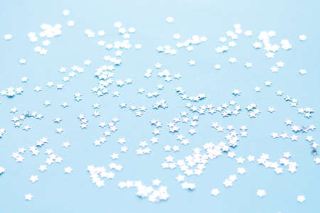 Silver shiny stars glitter or confetti on light blue backgroundの写真素材